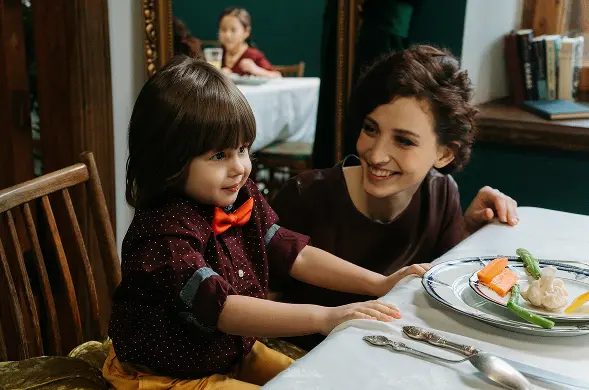 mother sitting at table with little kid happy their life insurance quotes secure family futures